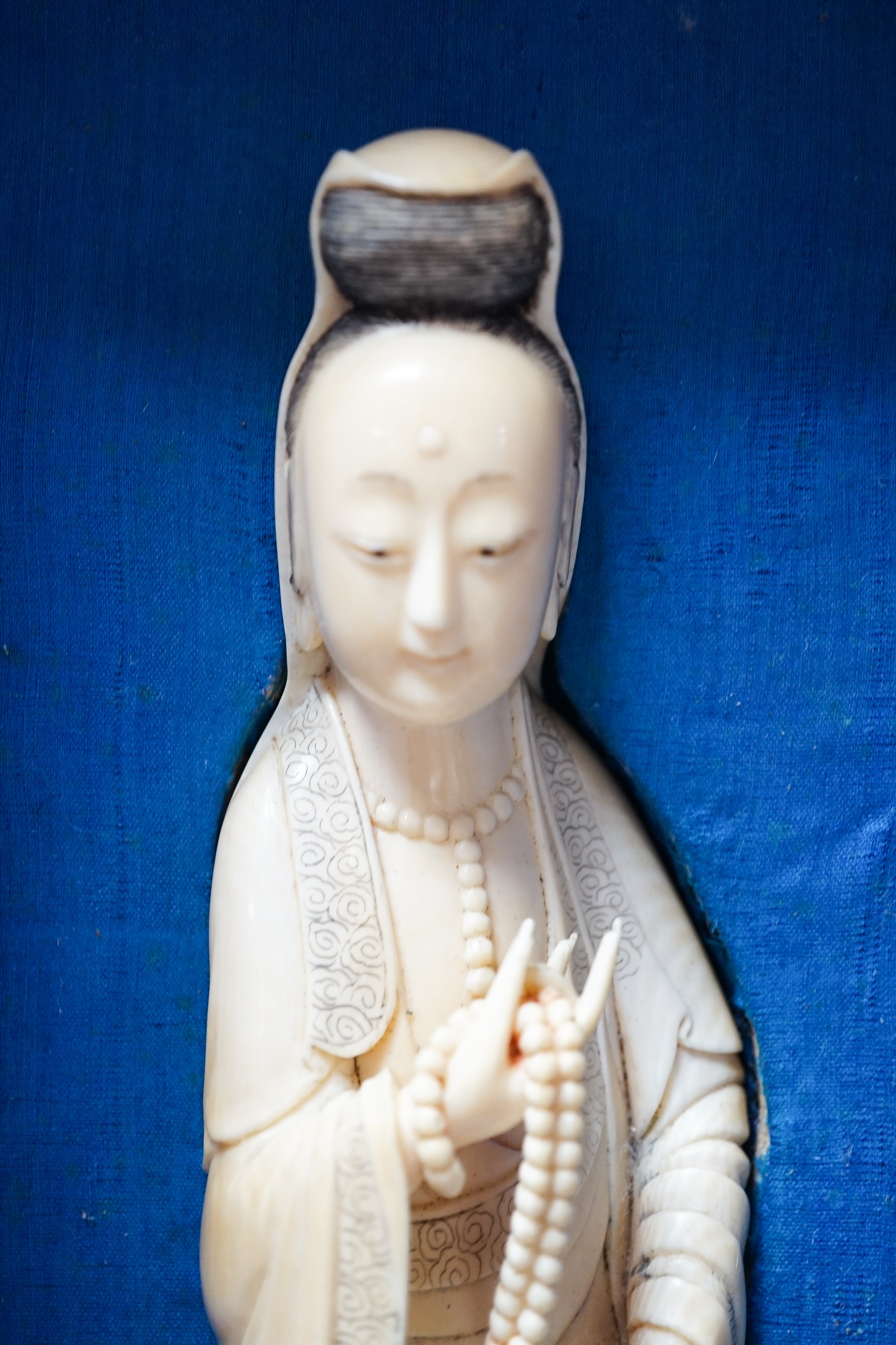 An early 20th century Chinese ivory figure of Guanyin holding a Buddhist rosary 25cm, wood stand and case